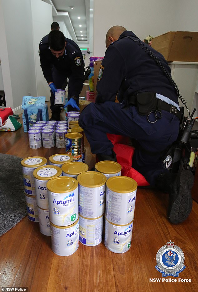 Investigators examine some of the scores  of tins of Aptamil Pro, a formula mix, found at her property