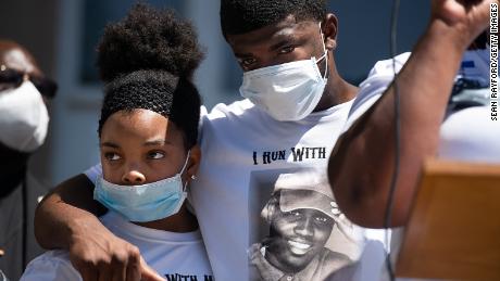 Family of Ahmaud Arbery embrace outside courthouse during a protest of his shooting death.