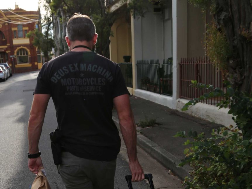 A man walks in the street with luggage