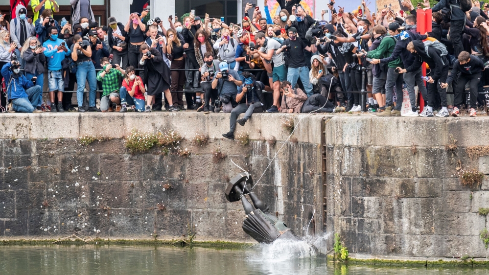 The statue of Edward Colston falls into the water after protesters pulled it down in Bristol